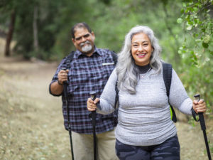 A senior mexican couple hiking in the woods.