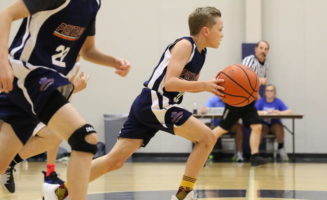 basektball player at Sanford Pentagon dribbles with referee in background