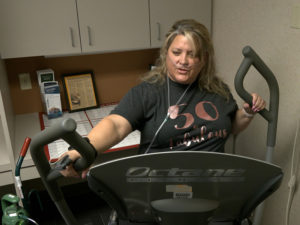 A 50-year-old woman on oxygen works out on a treadmill.