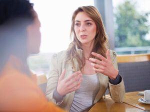 Midlife professional women talk in a coffee shop.