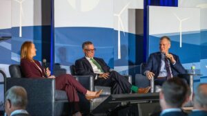 A businesswoman and two businessmen talk onstage at the Summit on the Future of Rural Health Care.