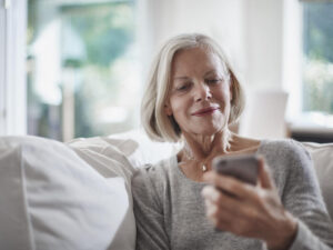Senior woman looking on cell phone at home.