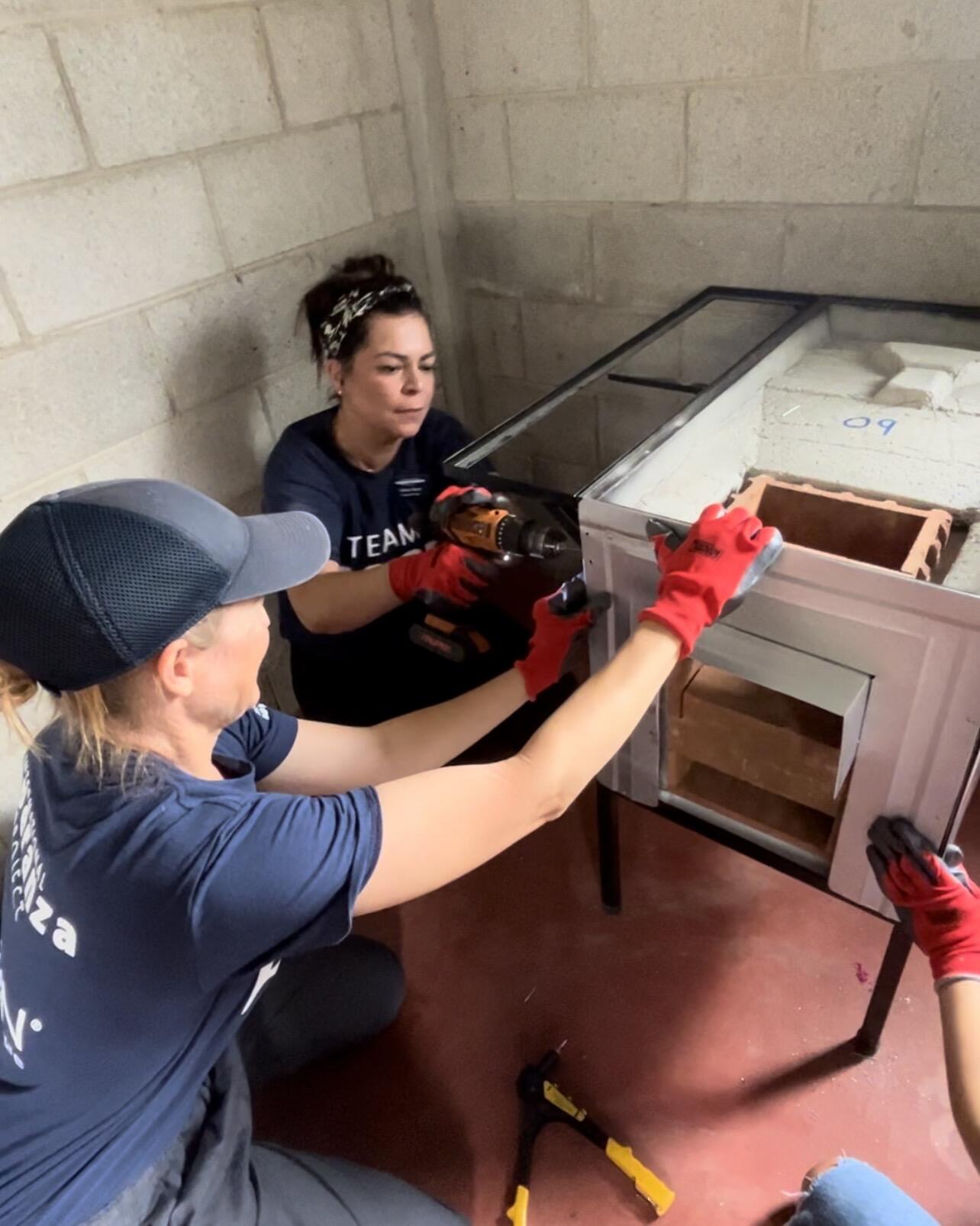 Two Sanford Health nurses build a woodburning stove with power tools inside a cinderblock home in Guatemala.
