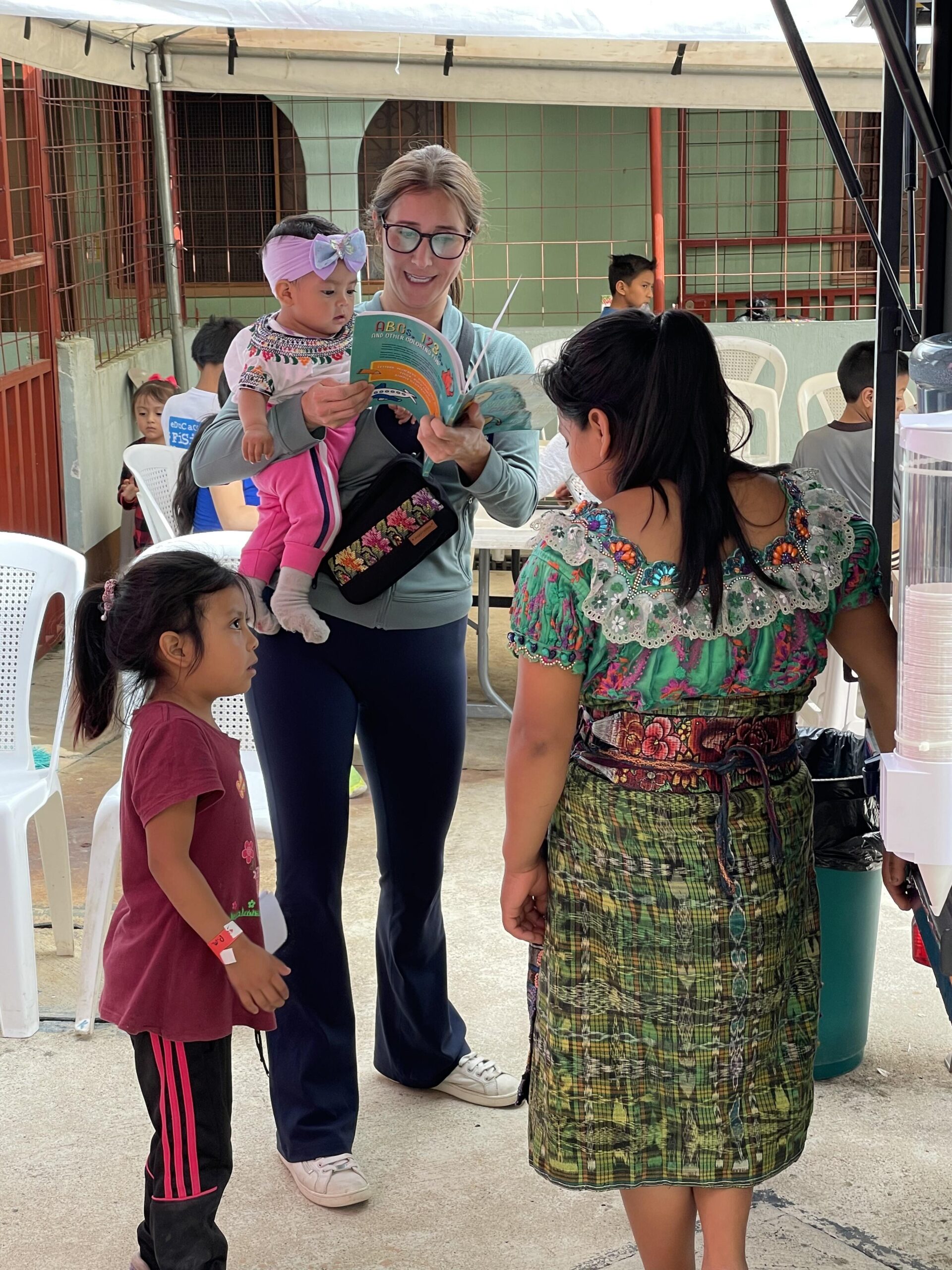 A Sanford Health nurse holds a baby while speaking to her mother and siblings in a Guatemalan clinic.