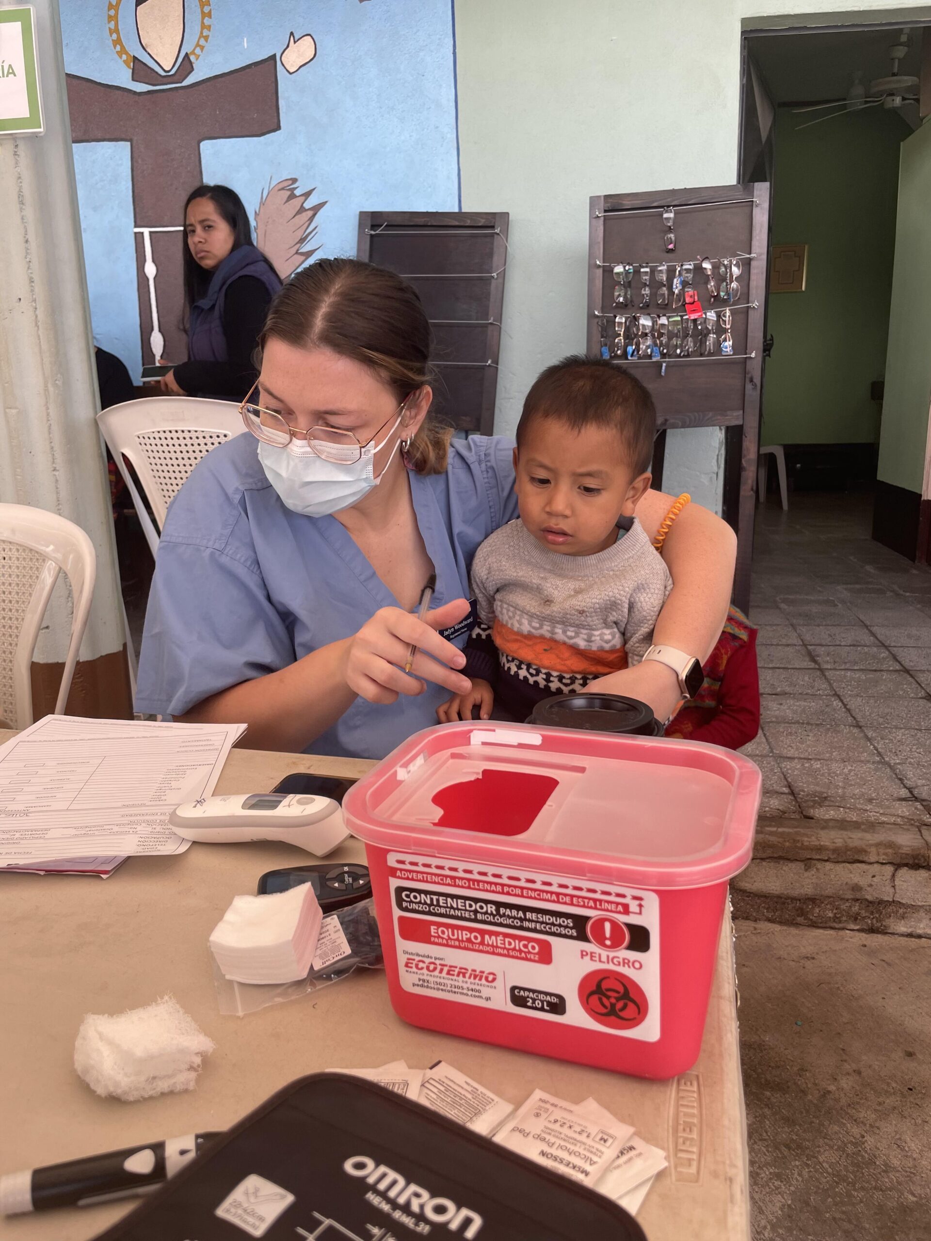 A Sanford Health nurse holds a young patient on her lap at a clinic in Guatemala.
