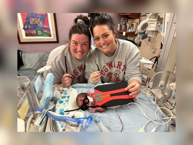 two women with small baby in neonatal intensive care nursery