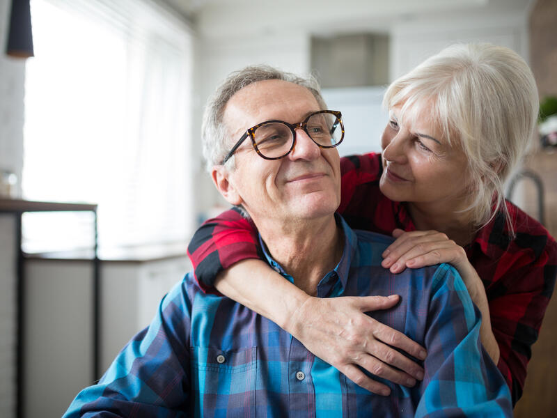 Portrait of happy senior woman embracing her husband