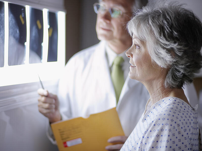 Doctor Discussing X-Rays with Middle Aged Woman