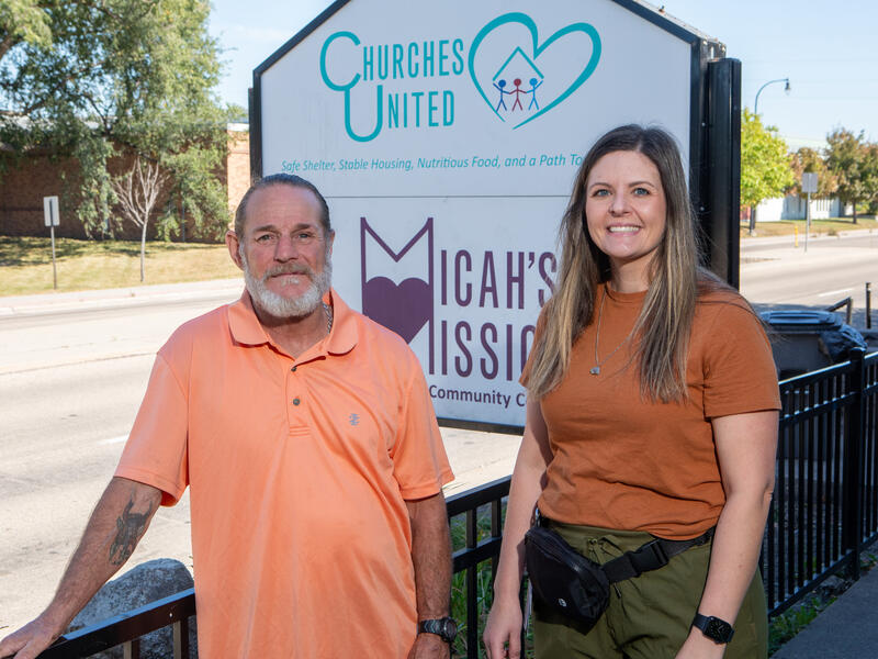 man and woman pose outside of Micah's Mission homeless shelter