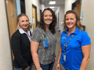 staff therapist and co-workers stand for photo in hallway