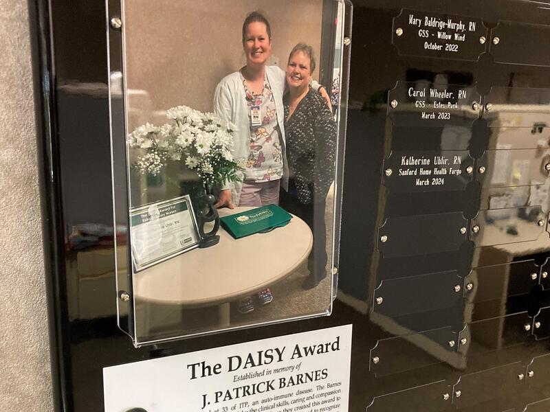 Closeup of DAISY Award plaque with name and photo of home health nurse Katherine Uhlir and her patient, Gail Agnes.