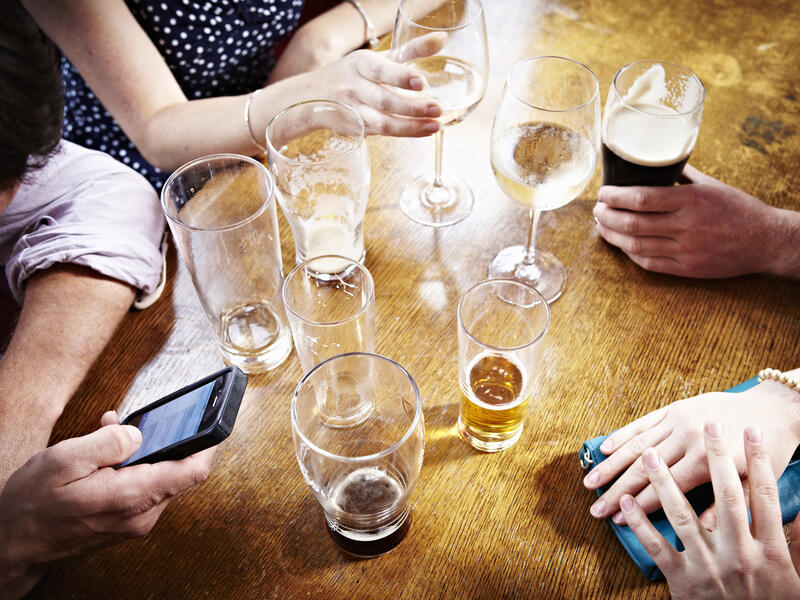 several people sit around table with empty beer and alcohol glasses