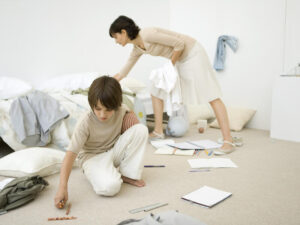 Mom and son clean the boy's messy bedroom.