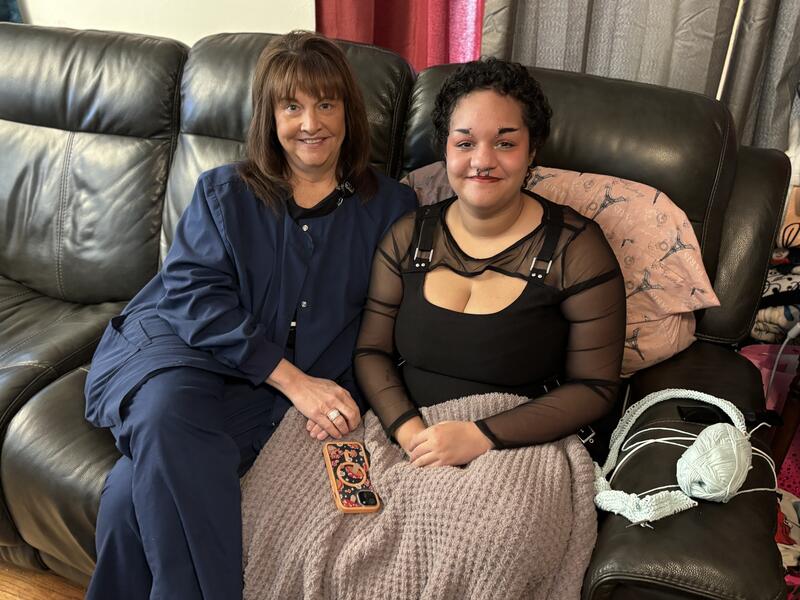 Nurse and teen patient sit together on the couch.