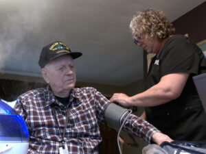 Home health nurse checks blood pressure of patient