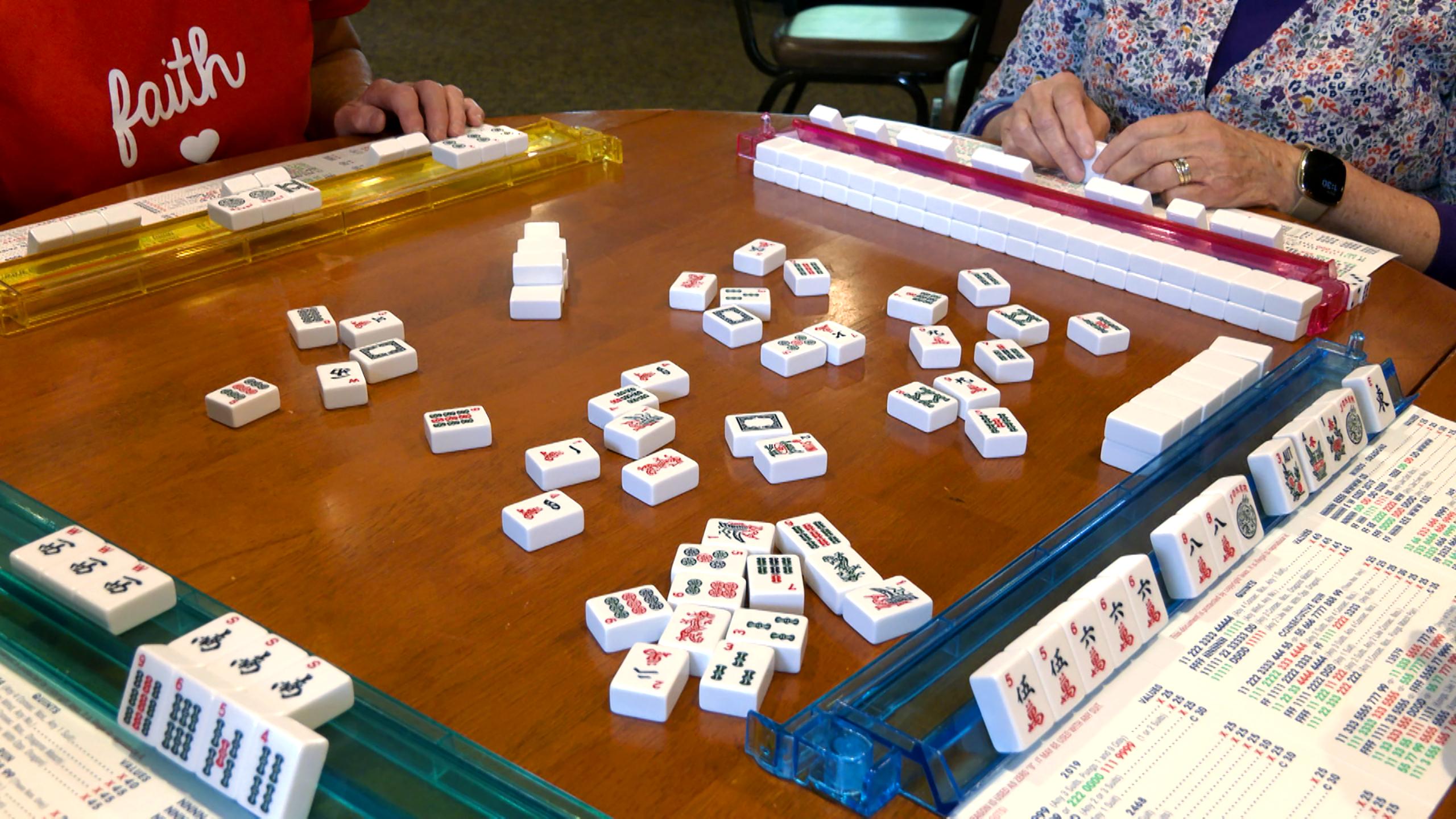A table is full of tiles in the middle of a mahjong game.