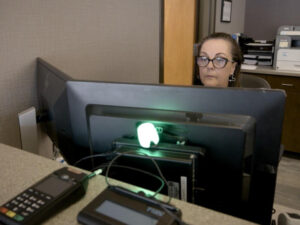 Woman at a computer with two monitors.