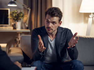 Concerned young man talks to a therapist.