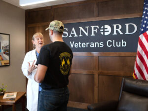 A doctor talks with a military veteran in the Sanford Veterans Club.