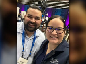 Two nursing home workers smile with Good Samaritan logos on their shirts and badges.