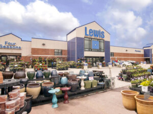 Lewis Drug store exterior in summer with planters and garden plants for sale in the foreground.