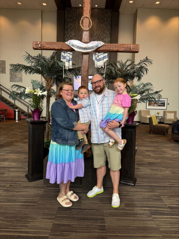 Young family of four poses for a photo after a church service.