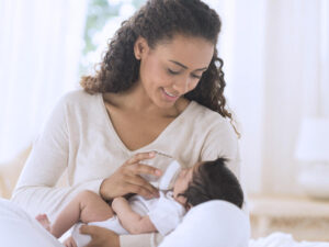 Mother bottle feeds infant