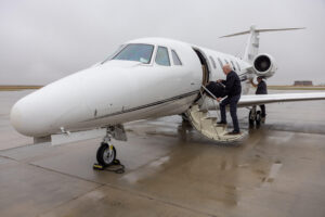 Doctor climbs aboard private jet on a rainy day.