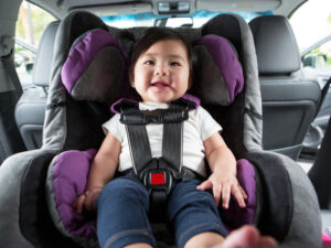 Baby sitting in rear-facing car seat, ready to go for a ride.