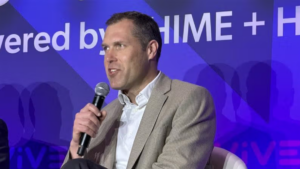 Screenshot of businessman with microphone