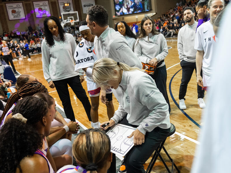 Phoenix Mercury basketball coaches huddle with their team during a timeout.
