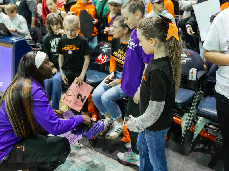 WNBA player Kahleah Copper gives her game shoes to a young fan.