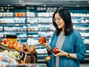 Woman shopping for fresh organic fruits in supermarket.