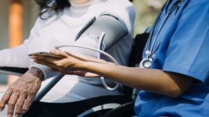 Healthcare worker takes a senior patient's blood pressure.