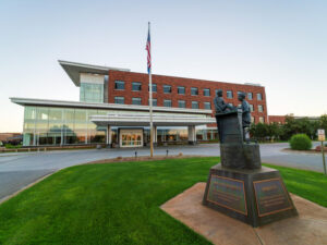 Exterior of Sanford Bemidji Medical Center with statue of nurse and patient in front lawn.