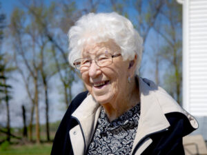Senior woman smiles on a sunny day at the farm.